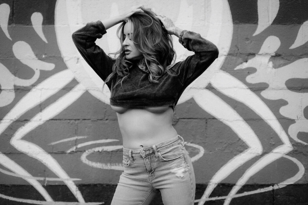 Tattooed woman standing in front of graffiti art in Midtown Sacramento