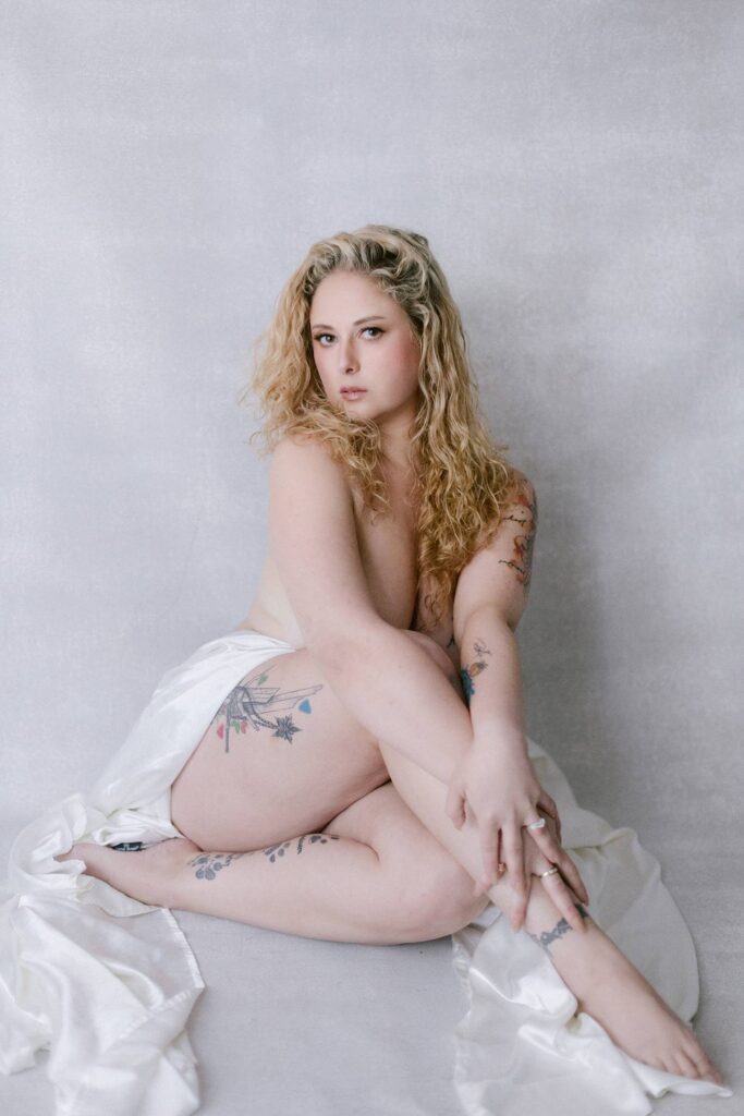 Fine art boudoir portrait in Sacramento featuring a woman wrapped in white satin fabric, highlighting confidence, self-expression, and natural beauty.