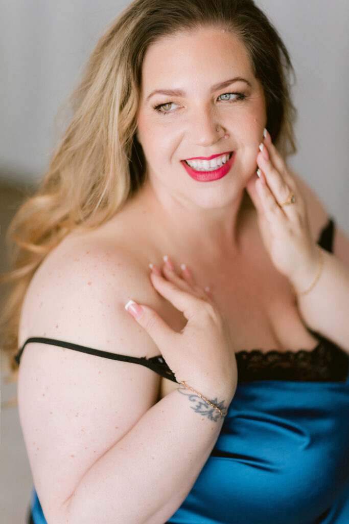 Smiling woman in black lace lingerie during her Sacramento boudoir client experience
